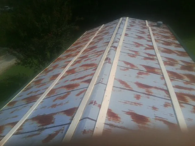 Rusted metal roof panels with new wood purlins before replacement — Storm Damage Roof Repair in Lascassas by Roofing Brothers