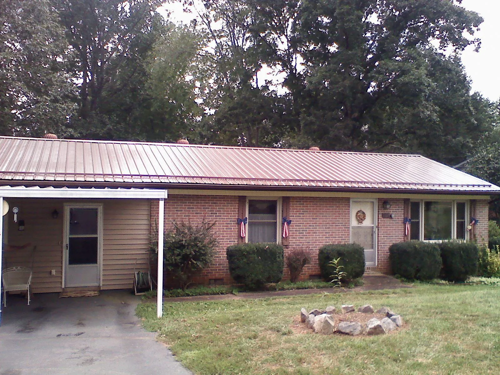 Bronze metal roof and carport on a brick ranch home — Roof Repair work by our crew in Lascassas